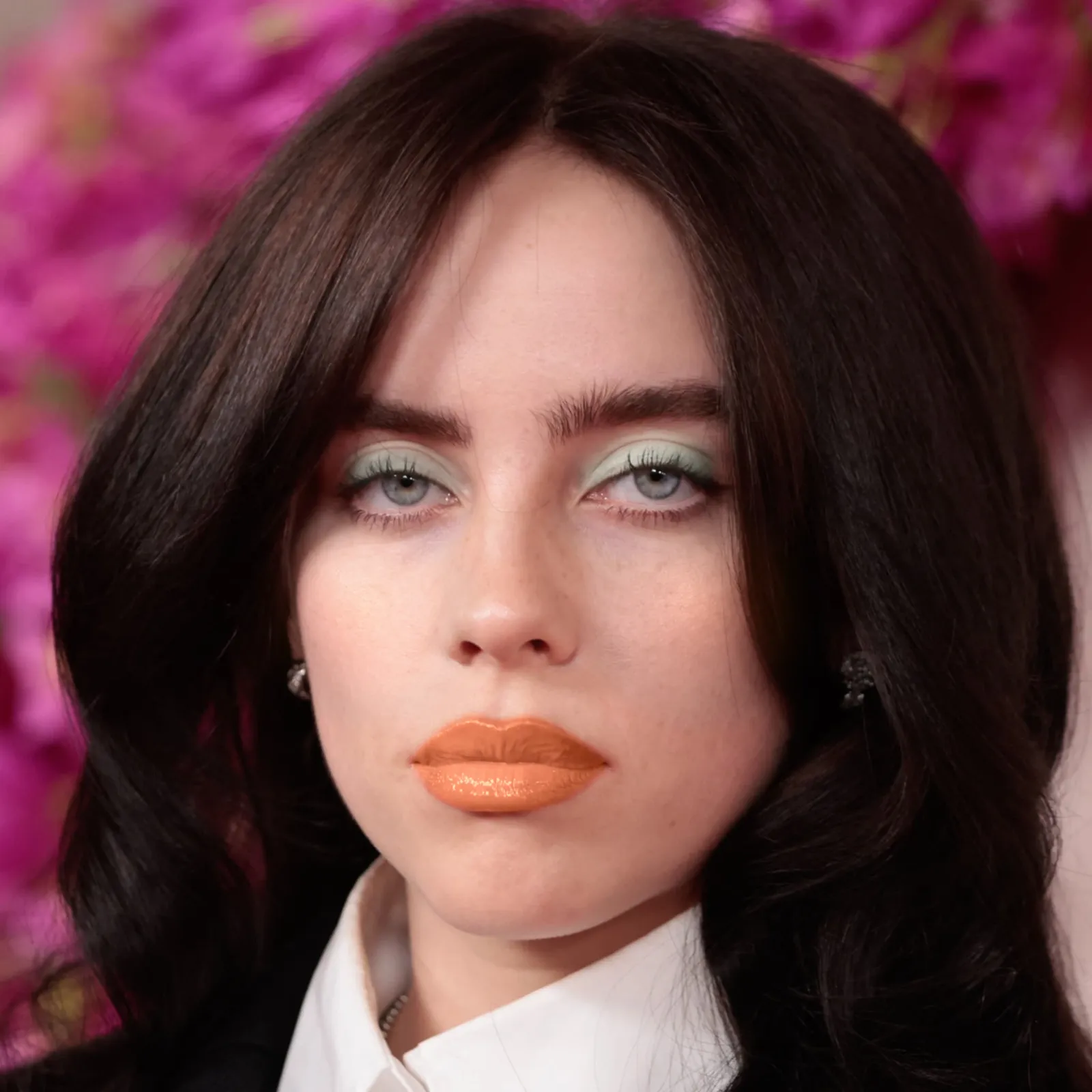 Billie Eilish with warm Spring makeup — mint shadow and orange lip