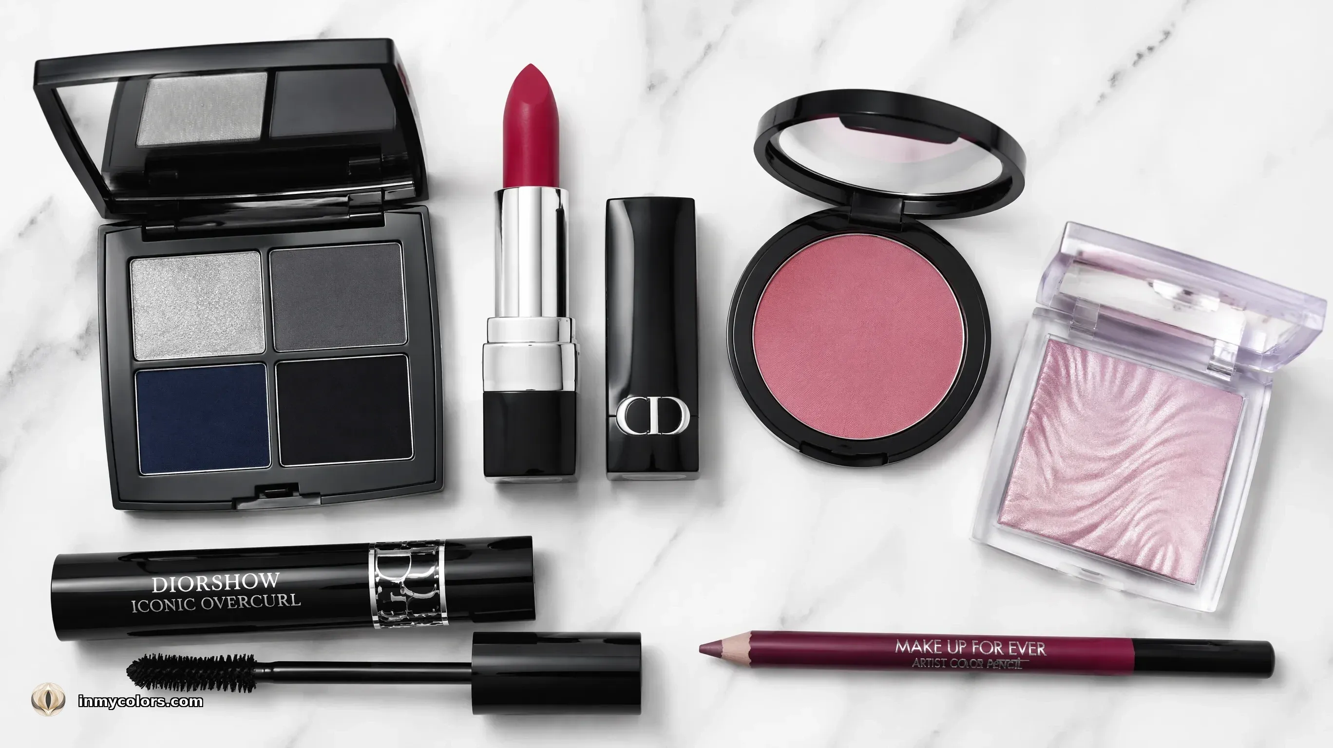 True Winter makeup products flatlay — cool charcoal eyeshadow palette, true red and fuchsia lipsticks, cool rose blush, silver liner, cool-toned foundation, black mascara on marble